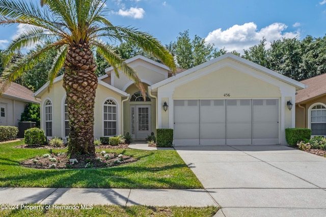 view of front of property with a garage and central AC