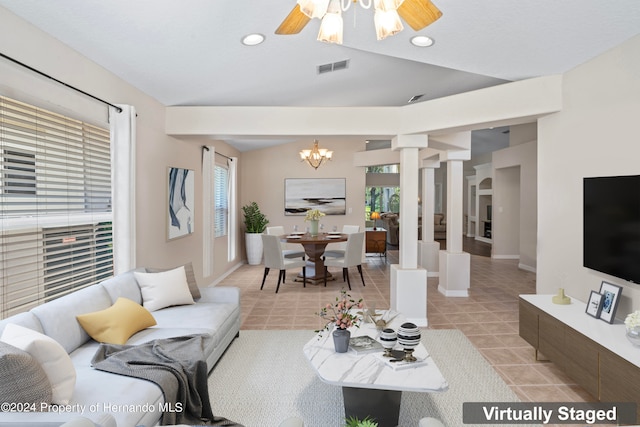 living room featuring ornate columns, ceiling fan with notable chandelier, a wealth of natural light, and light tile patterned floors