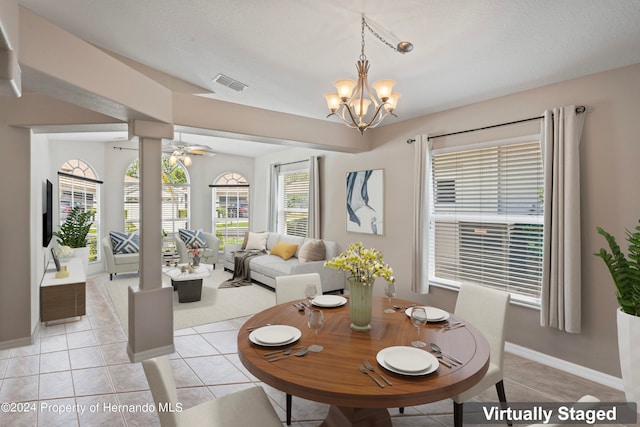 dining area with light tile patterned flooring and ceiling fan with notable chandelier