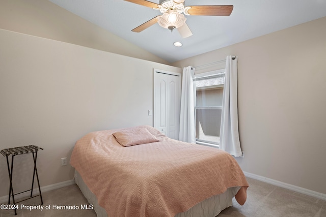 bedroom featuring light colored carpet, ceiling fan, vaulted ceiling, and a closet