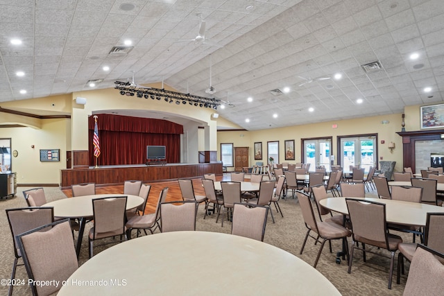 carpeted dining space with ceiling fan and vaulted ceiling