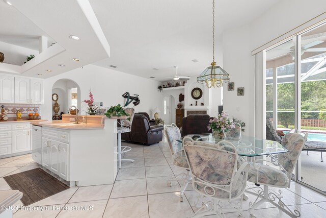 21312 Preservation Dr, Land O Lakes, FL 34638 - dining room featuring ceiling fan with notable chandelier, arched walkways, recessed lighting, and light tile patterned floors