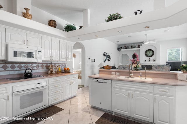 21312 Preservation Dr, Land O Lakes, FL 34638 - kitchen with open floor plan, white cabinetry, white appliances, a sink, and arched walkways