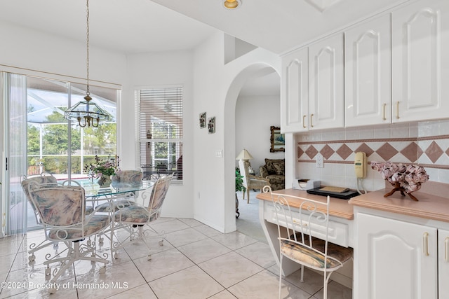 21312 Preservation Dr, Land O Lakes, FL 34638 - dining area with light tile patterned floors, arched walkways, and a wealth of natural light