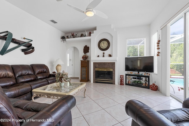 21312 Preservation Dr, Land O Lakes, FL 34638 - living room with light tile patterned floors, arched walkways, visible vents, a high end fireplace, and a ceiling fan