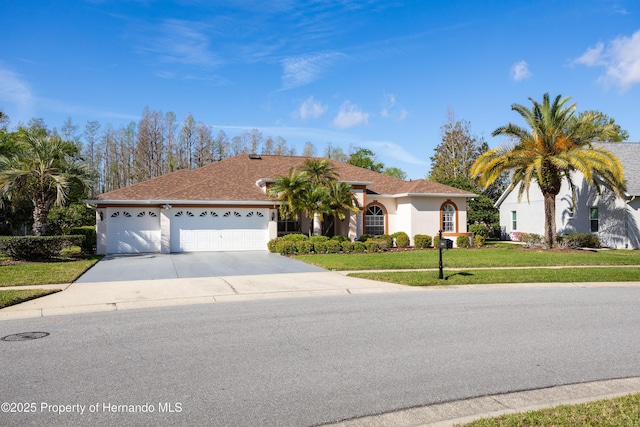 21312 Preservation Dr, Land O Lakes, FL 34638 - view of front facade featuring driveway, a front yard, an attached garage, and stucco siding