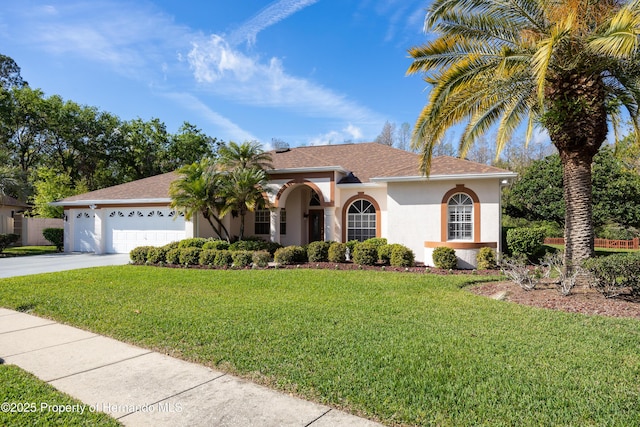 21312 Preservation Dr, Land O Lakes, FL 34638 - mediterranean / spanish-style home featuring a garage, a front yard, concrete driveway, and stucco siding
