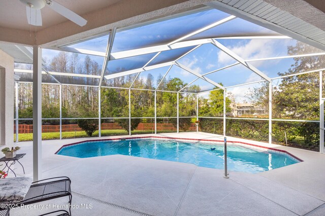 21312 Preservation Dr, Land O Lakes, FL 34638 - outdoor pool with a ceiling fan, glass enclosure, fence, and a patio area