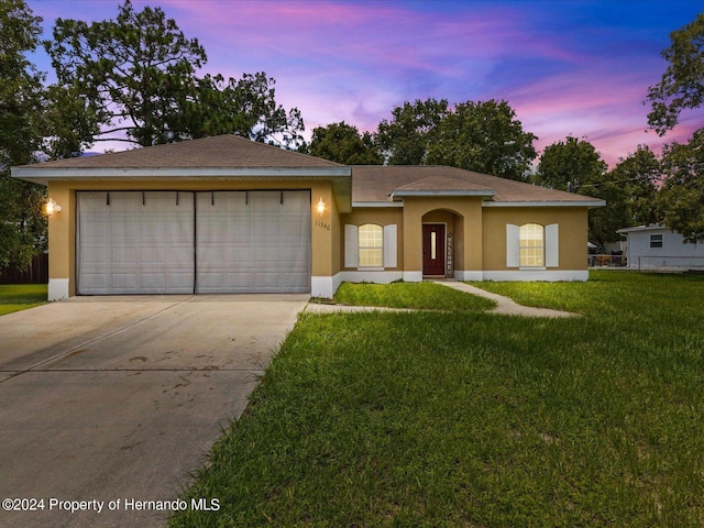 view of front of house with a garage and a lawn