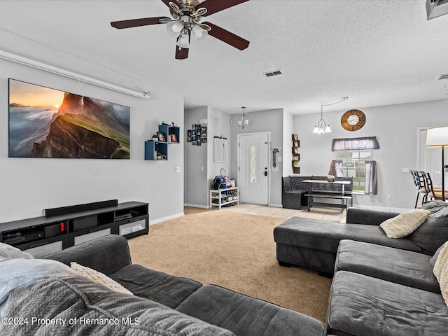 carpeted living room with a textured ceiling and ceiling fan with notable chandelier