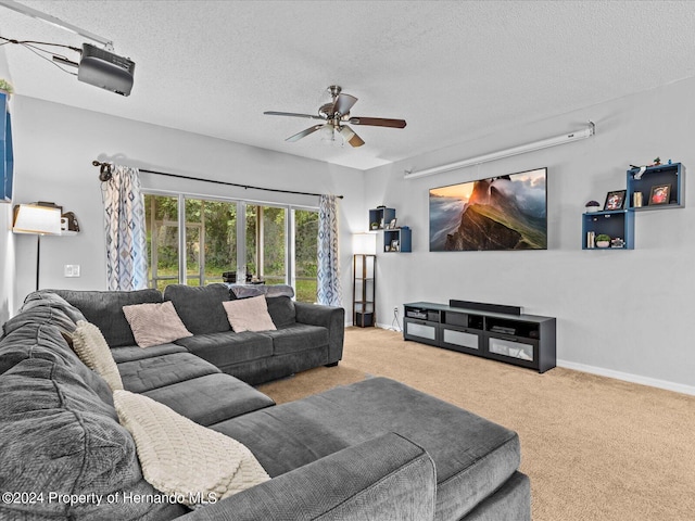 living room with ceiling fan, a textured ceiling, and light carpet