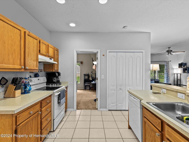 kitchen featuring sink, ceiling fan, a textured ceiling, light tile patterned floors, and white appliances