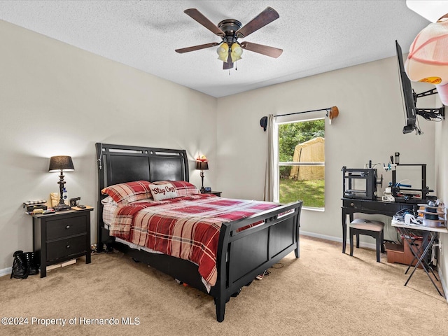 carpeted bedroom featuring ceiling fan and a textured ceiling