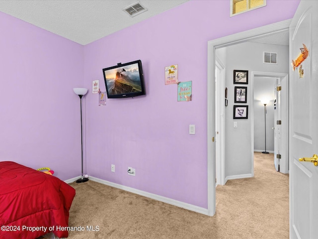 carpeted bedroom featuring a textured ceiling