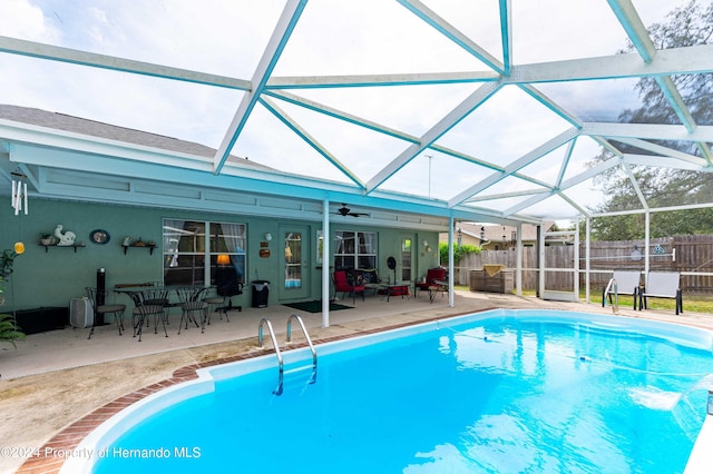 view of swimming pool with outdoor lounge area, glass enclosure, and a patio area