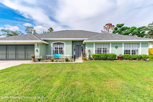 single story home featuring a garage and a front yard