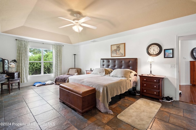 bedroom featuring ceiling fan and a raised ceiling