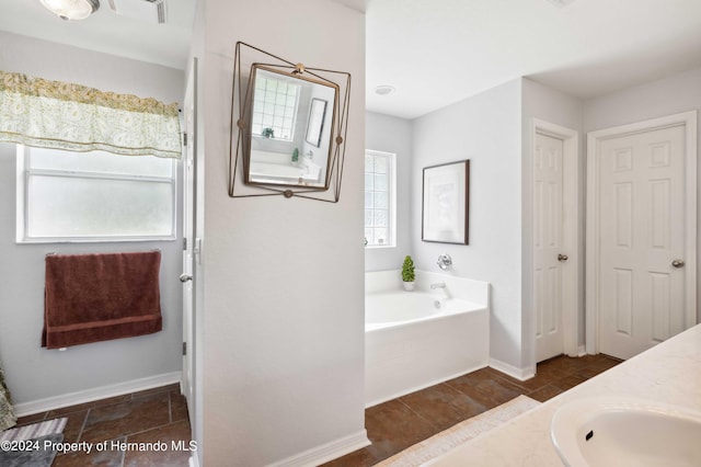 bathroom with a relaxing tiled tub and vanity