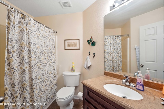 bathroom featuring walk in shower, vanity, and toilet