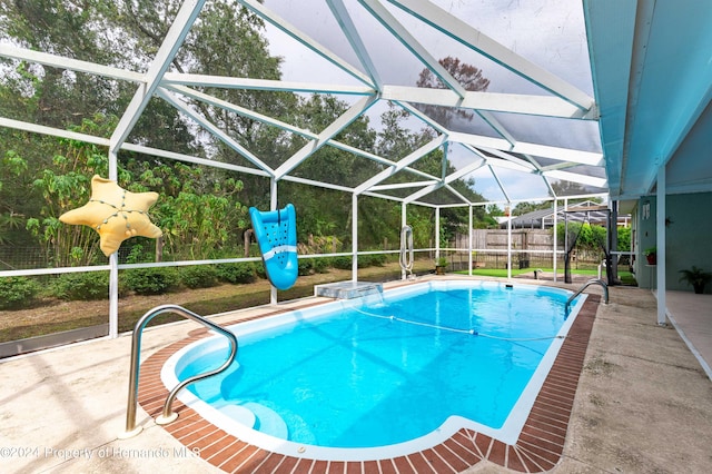 view of swimming pool with a patio area and a lanai