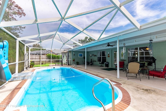 view of swimming pool with a lanai, ceiling fan, and a patio area