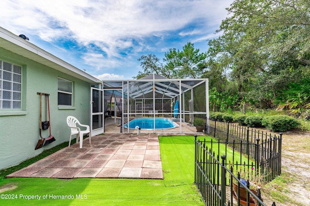 view of pool featuring a lanai, a lawn, and a patio