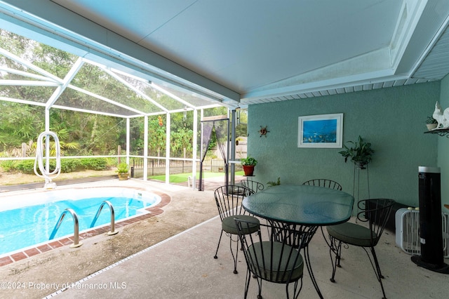 view of swimming pool with a patio area and a lanai