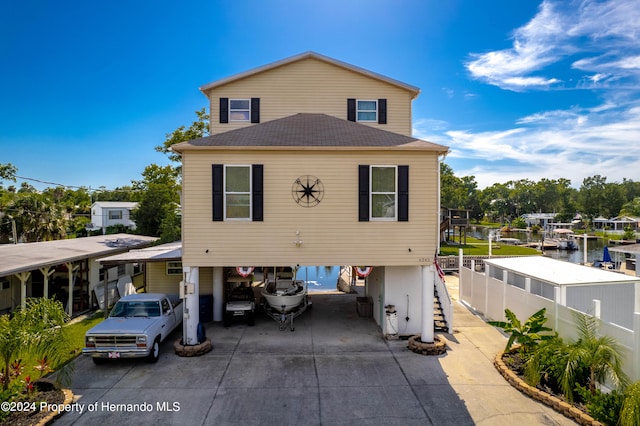 view of front facade with a carport and a water view