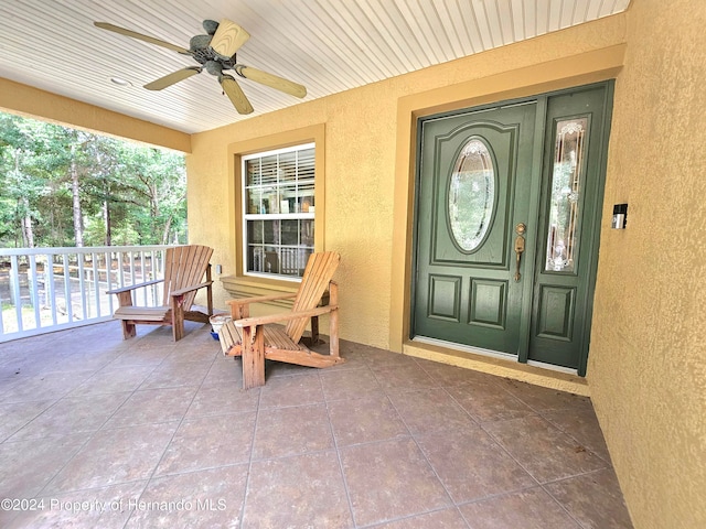 entrance to property featuring a porch and ceiling fan