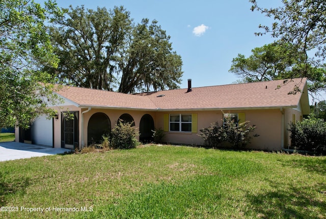 ranch-style home with a garage and a front yard