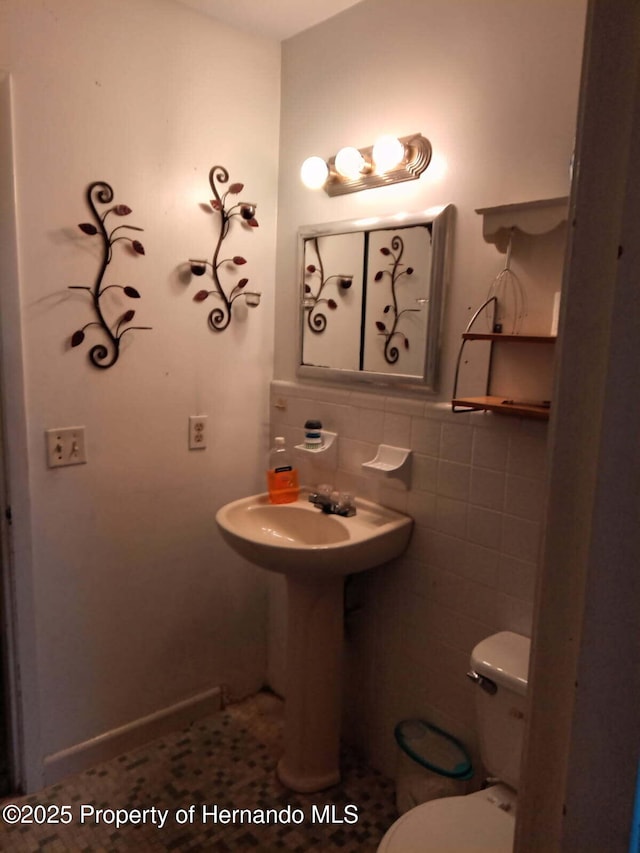 half bathroom with tile walls and toilet