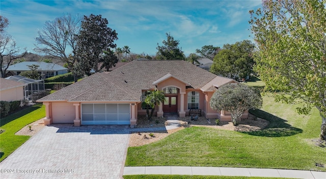 ranch-style house featuring a garage and a front lawn