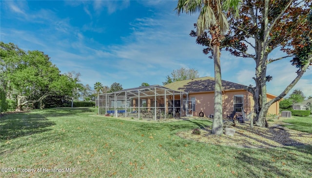 back of house featuring a lanai and a yard