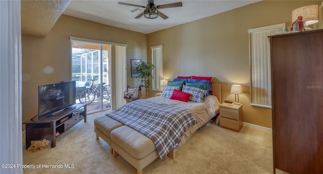 carpeted bedroom featuring access to outside, a textured ceiling, and ceiling fan