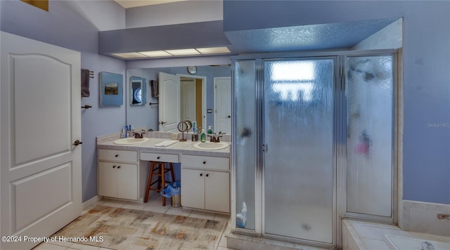 bathroom featuring tile patterned flooring, vanity, a textured ceiling, and a shower with door