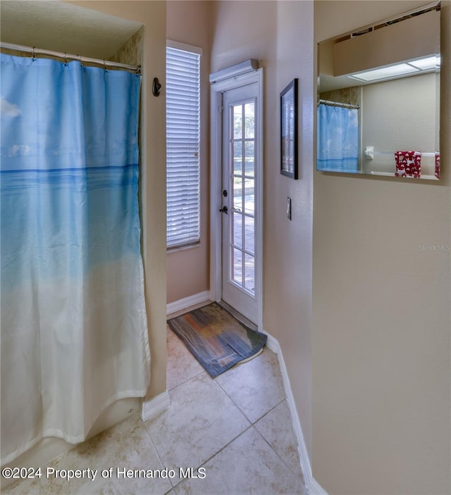 doorway to outside with light tile patterned floors