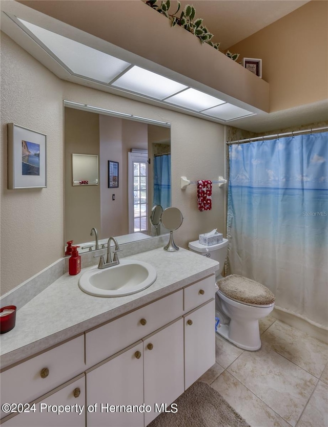 bathroom featuring toilet, vanity, and tile patterned flooring