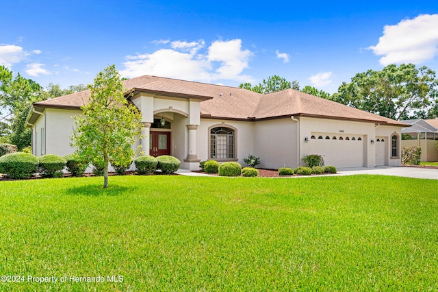 view of front of property featuring a garage and a front lawn