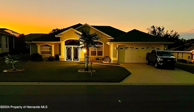 single story home with a garage and a yard