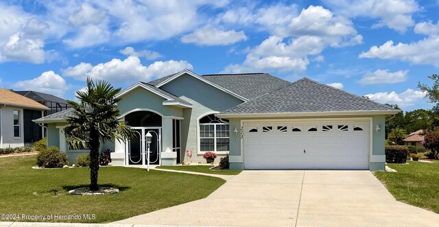 single story home featuring a garage and a front yard