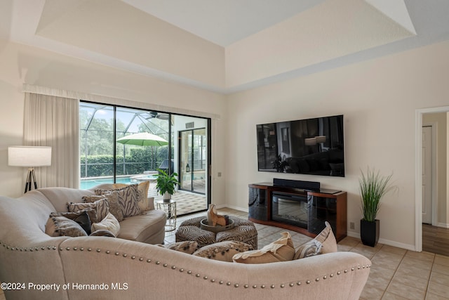 living room with light tile patterned floors and a raised ceiling