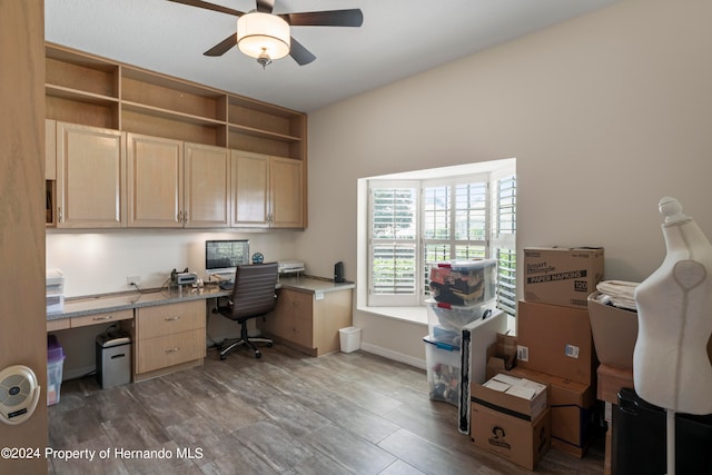 office space featuring ceiling fan, built in desk, and dark hardwood / wood-style floors