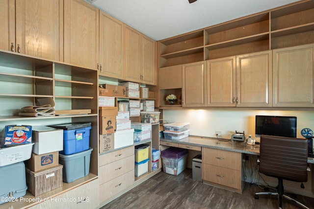 office with dark wood-type flooring and built in desk