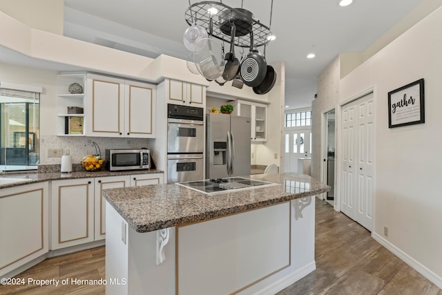 kitchen with hanging light fixtures, a breakfast bar area, a healthy amount of sunlight, and stainless steel appliances