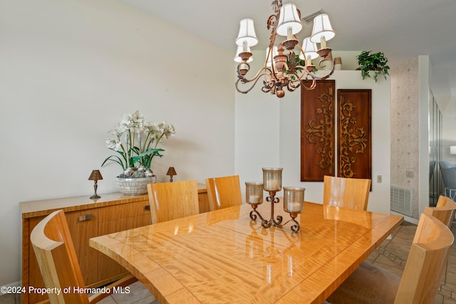 dining space with tile patterned flooring and an inviting chandelier