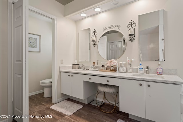 bathroom featuring toilet, vanity, and hardwood / wood-style flooring