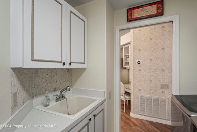 washroom featuring cabinets, washer and dryer, sink, and hardwood / wood-style floors