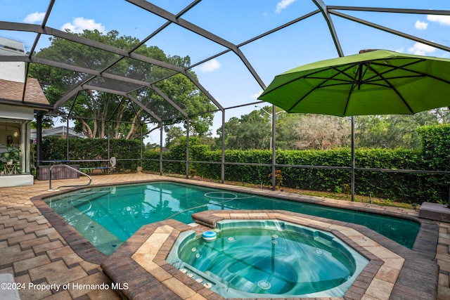 view of pool with a patio, a lanai, and an in ground hot tub