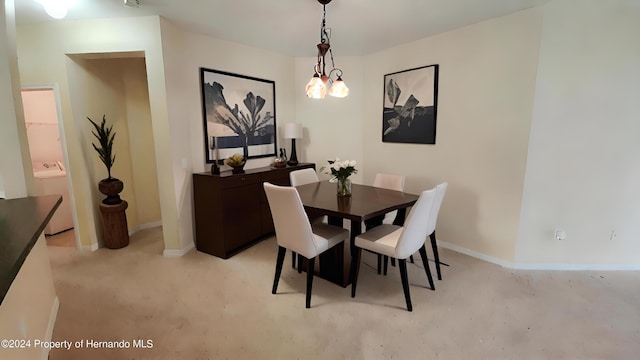 carpeted dining area featuring washer / clothes dryer and a notable chandelier