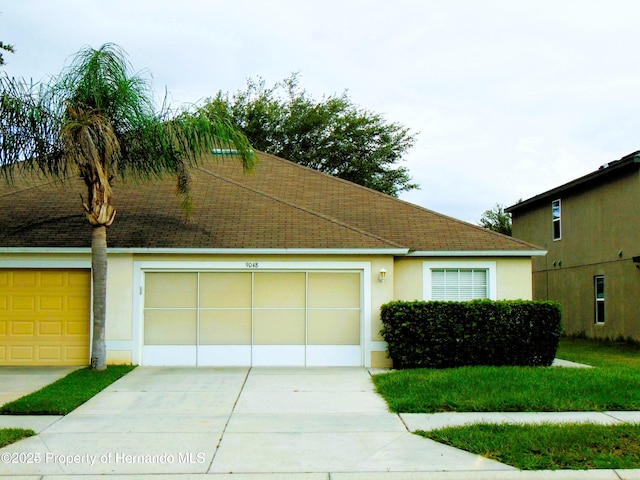 view of front of property featuring roof with shingles, driveway, an attached garage, and stucco siding